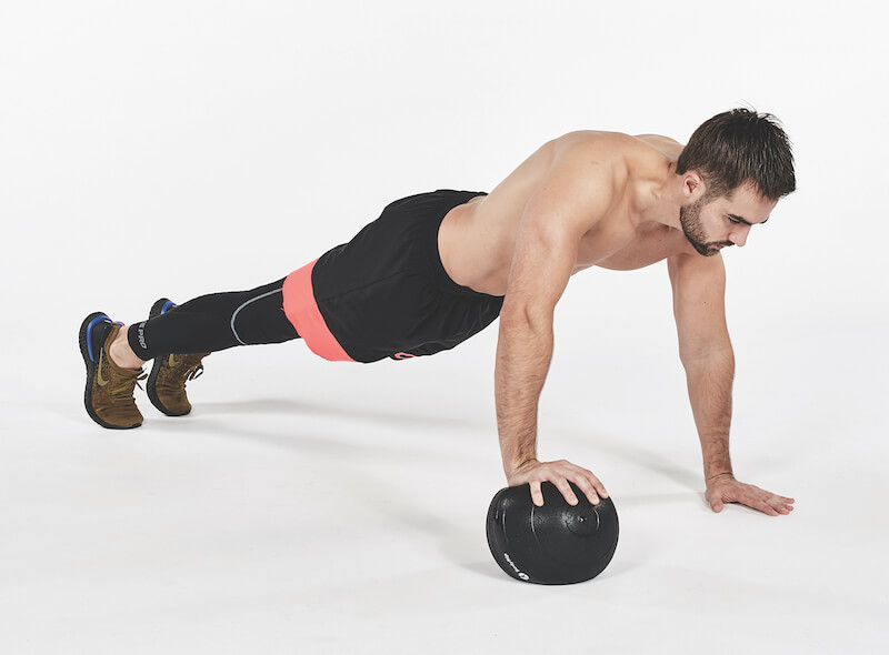 Man performing on and off finisher exercise on medicine ball, one of the best workout finishers