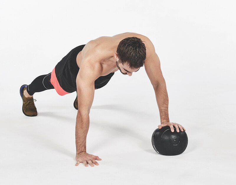 Man performing on and off exercise on medicine ball, one of the best workout finishers