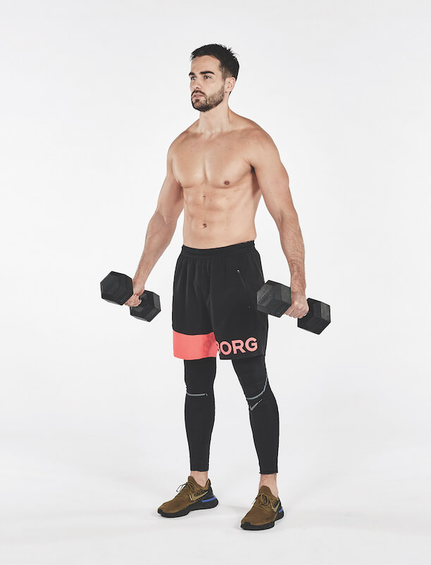topless man demonstrates how to perform reverse v exercise with dumbbells