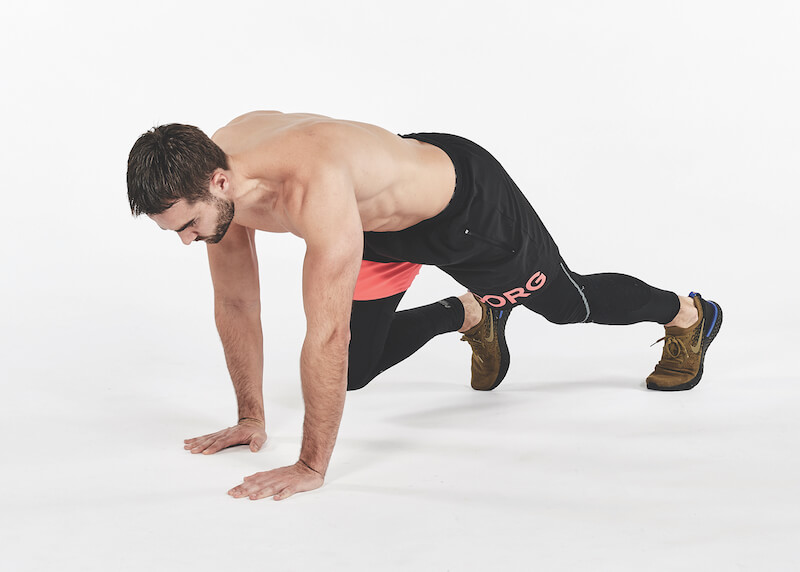 topless man demonstrates forward and back bear crawls exercise, one of the best workout finishers