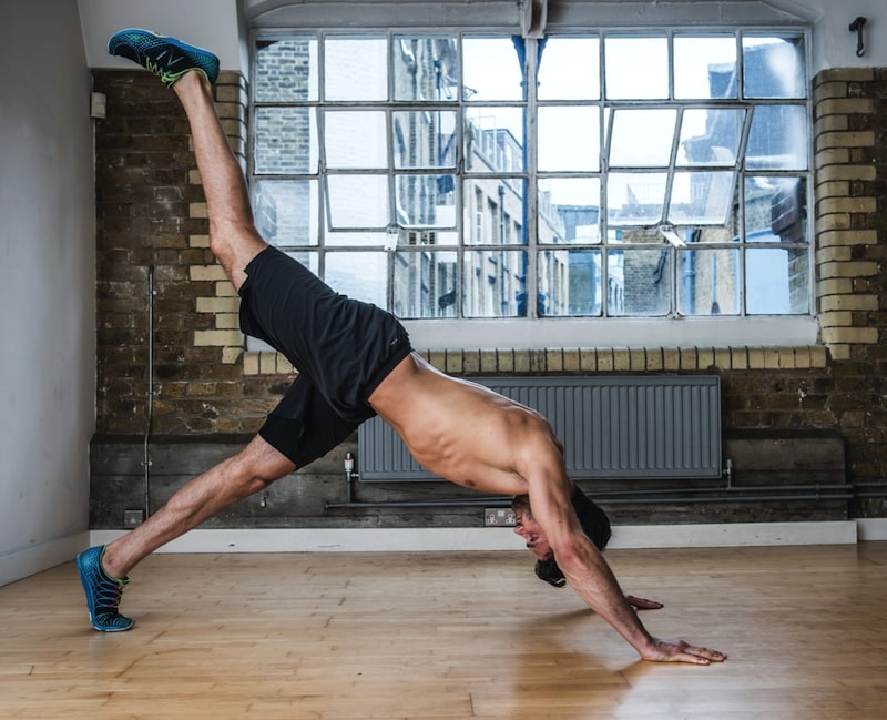 Man performing second part of single-leg knee drive – one of the best plank variations