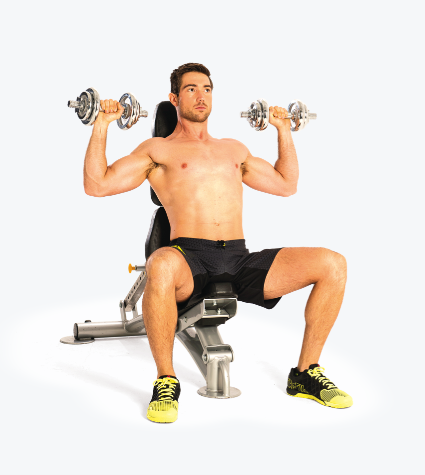 man demonstrating seated press; he sits on a bench holding two dumbbells at shoulder height, before raising them up then lowering them