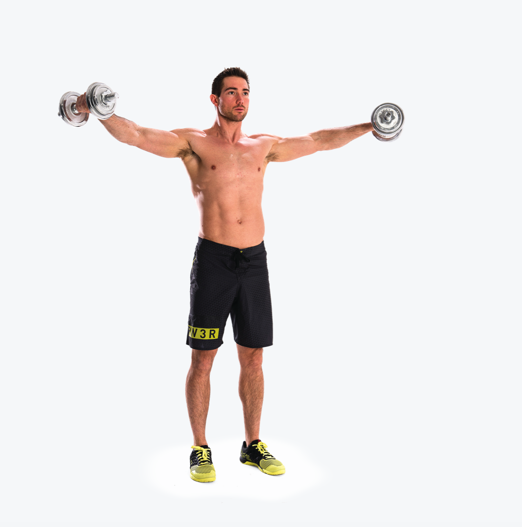 man demonstrated lateral raise; he stands tall holding two dumbbells at his side, before raising them to shoulder height then lowering