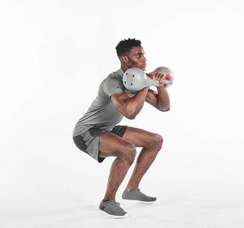 Squat to overhead press in home kettlebell workout
