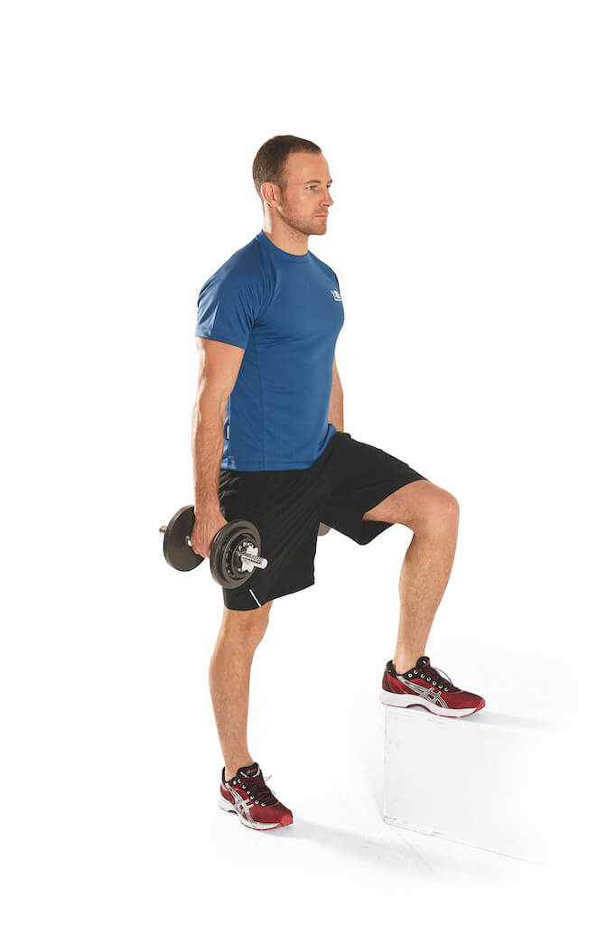 man performs dumbbell side step-up leg exercise on white block