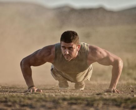 A soldier performing press-ups in the dust