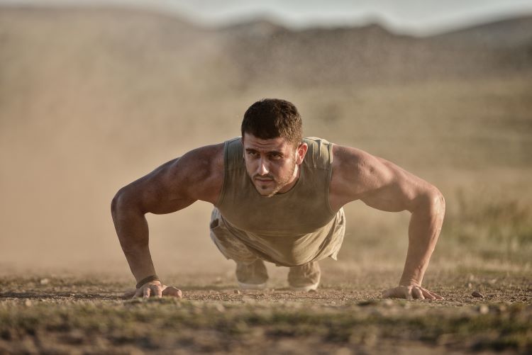 A soldier performing press-ups in the dust