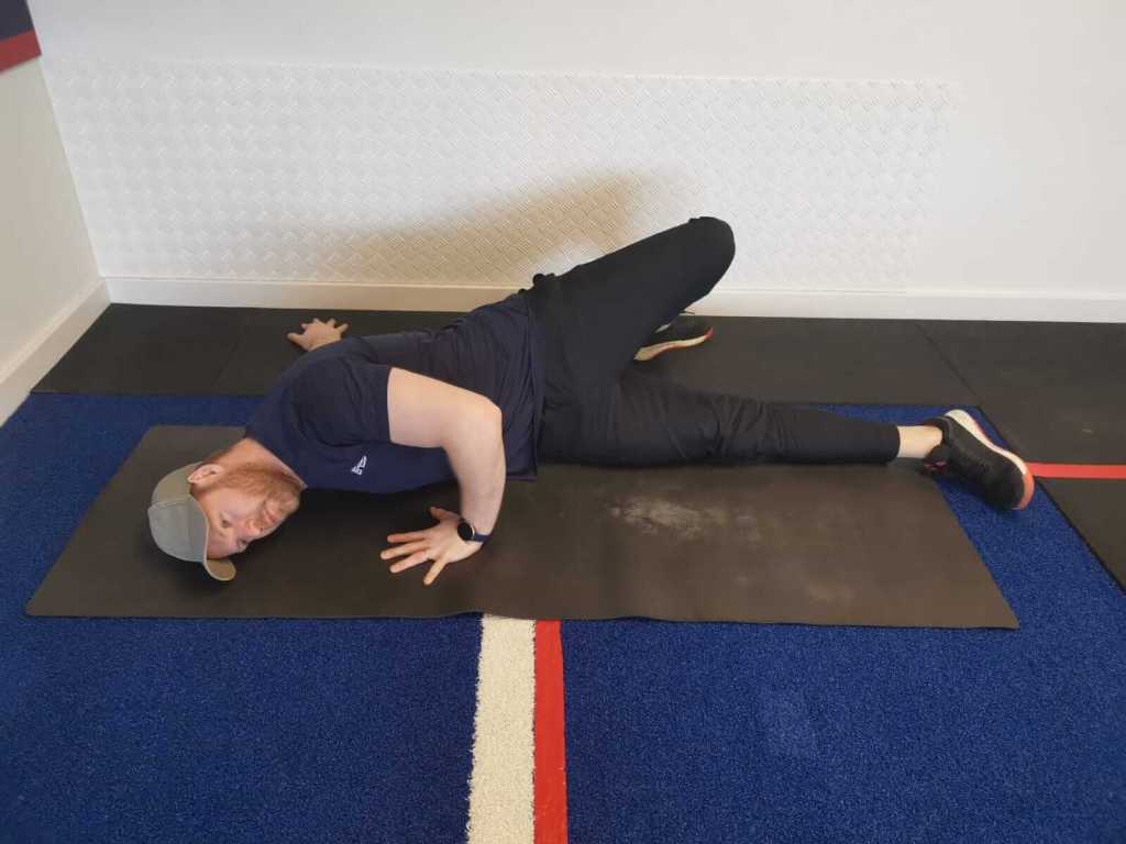 Man performing a twisted cross stretch