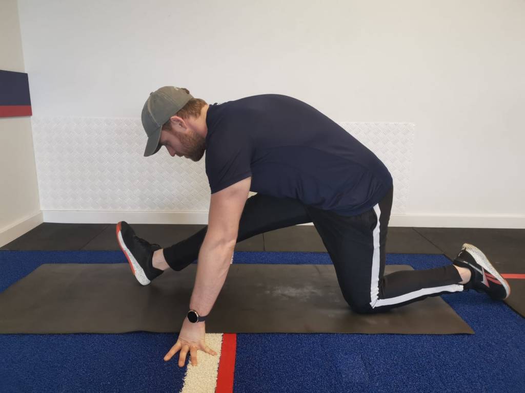 Man performing half-kneeling hamstring stretch