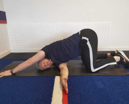 Man performing a thread-the-needle stretch
