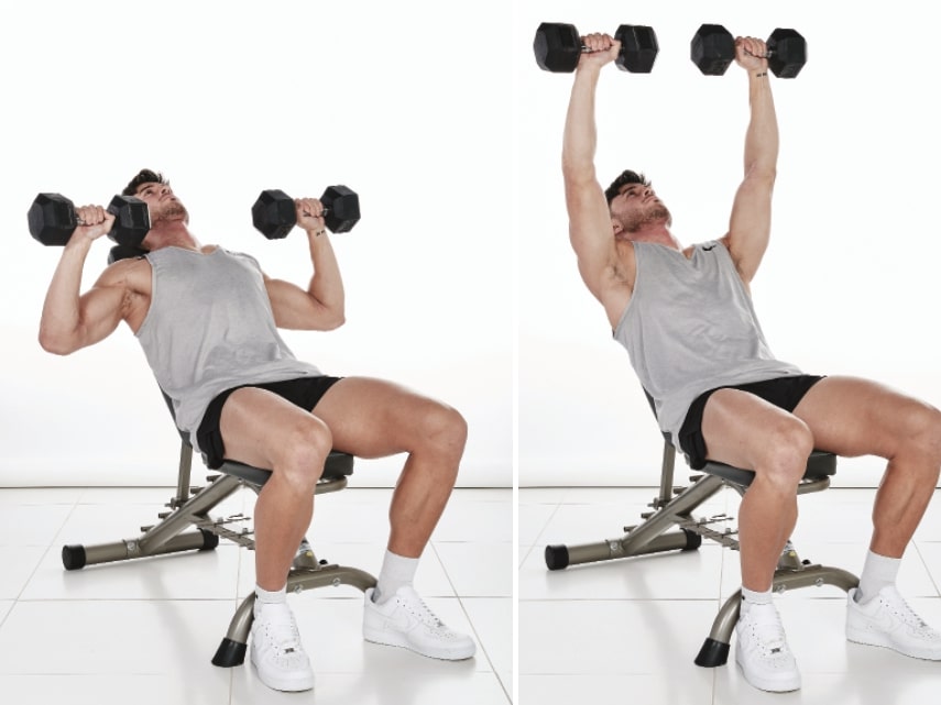 man demonstrates how to do an incline dumbbell bench press: sitting on a bench at a 45 degree incline, he holds two dumbbells at shoulder height, arms bent; then, he lifts the dumbbells above his head, before lowering to repeat