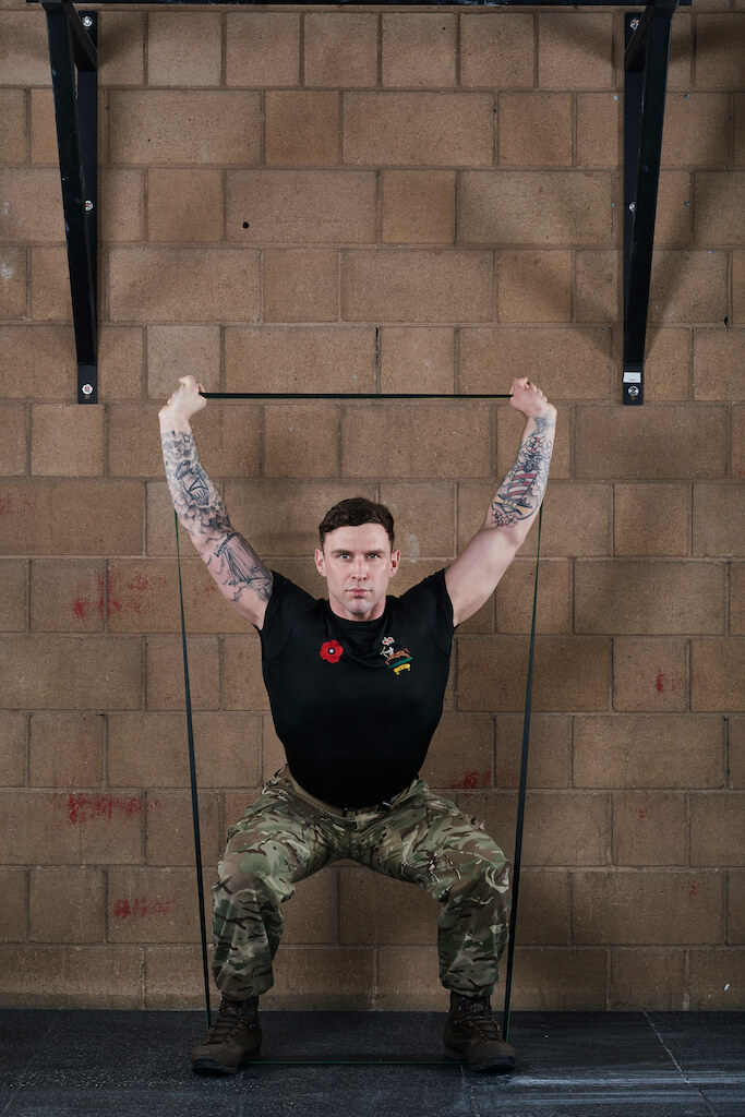 Man demonstrating a Resistance Band Overhead Squat