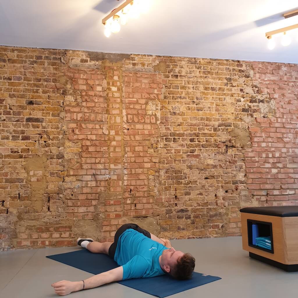 Man lying on the floor, performing a supine twist