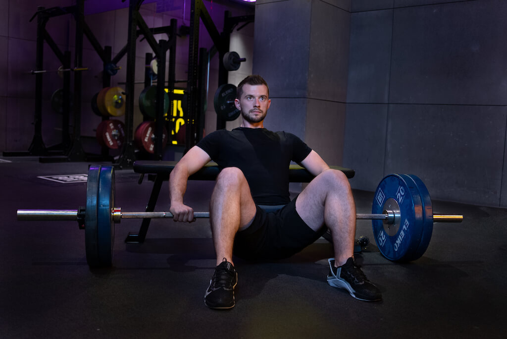 Front-on view of a man doing a barbell hip thrust