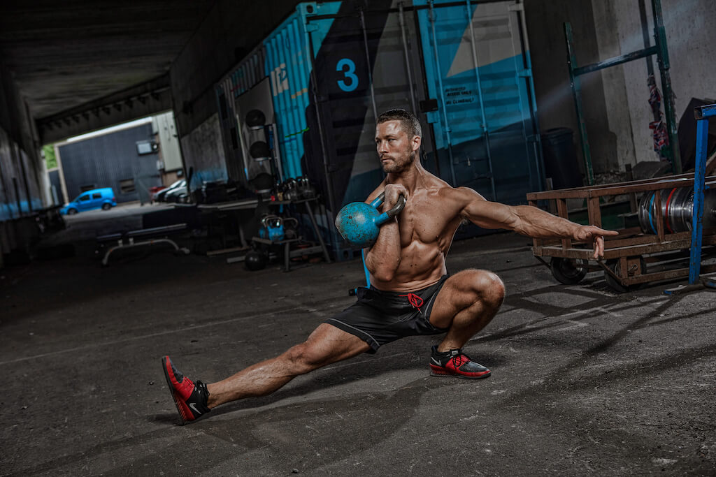 man performing kettlebell cossack squat exercise