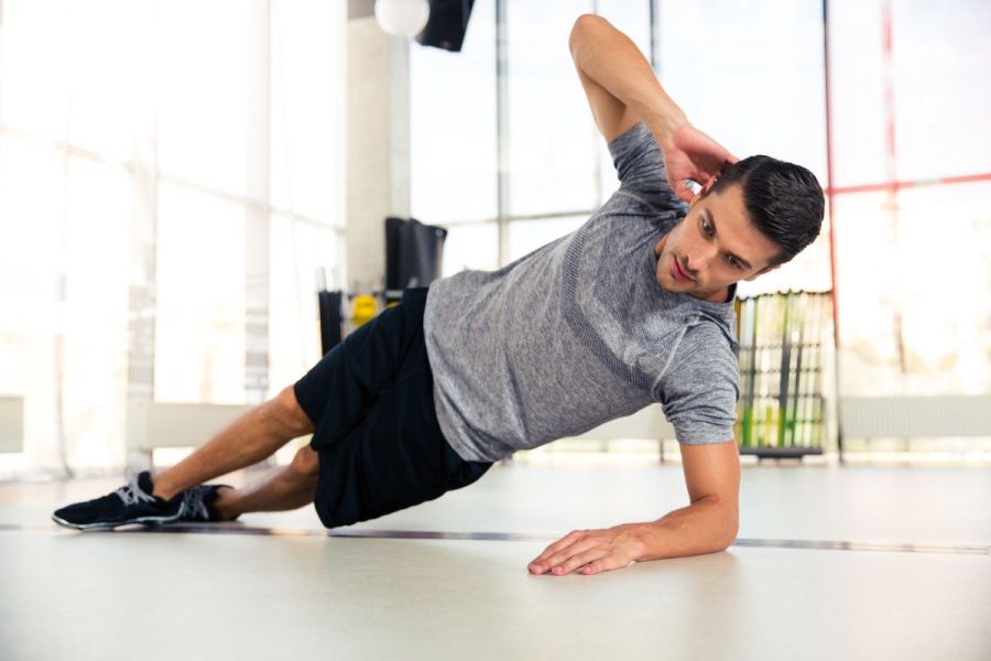 man performing side plank in 20-minute bodyweight abs workout
