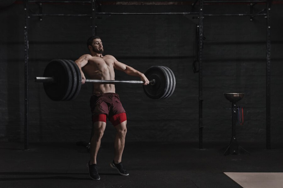 man performing Olympic lift with barbell in the gym