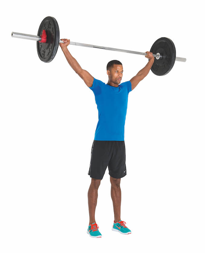 man performing the third stage of a barbell shrug