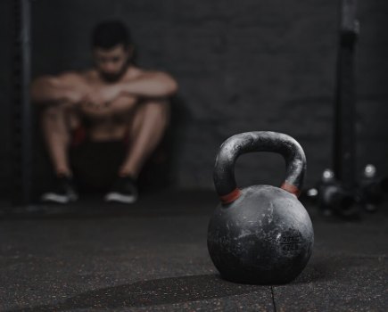 man sat down in the gym with kettlebell in the foreground to show lost exercise motivation