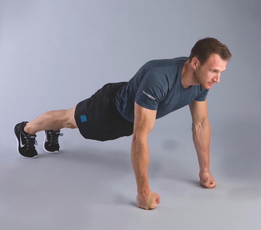 bodyweight hiit workout exercise: man performing knuckle press-up