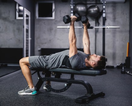Man performing chest press with dumbbells