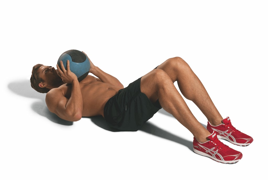 man demonstrating crunch and throw with medicine ball best abs exercises
