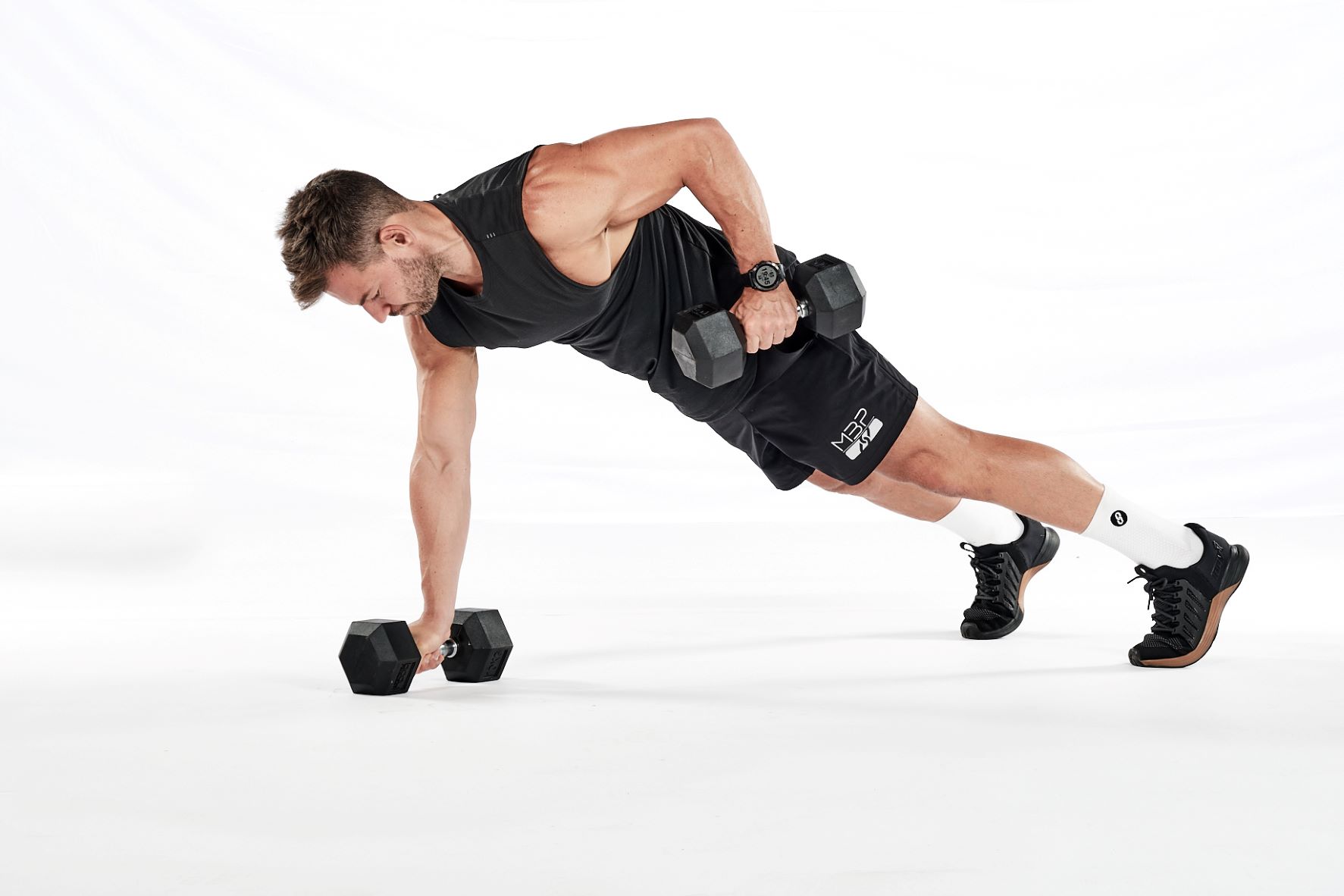 Three stages of the dumbbell renegade row – in a press-up position, holding a dumbbell in each hand; rowing up towards the hip with one hand; rowing up towards the hip with the other.