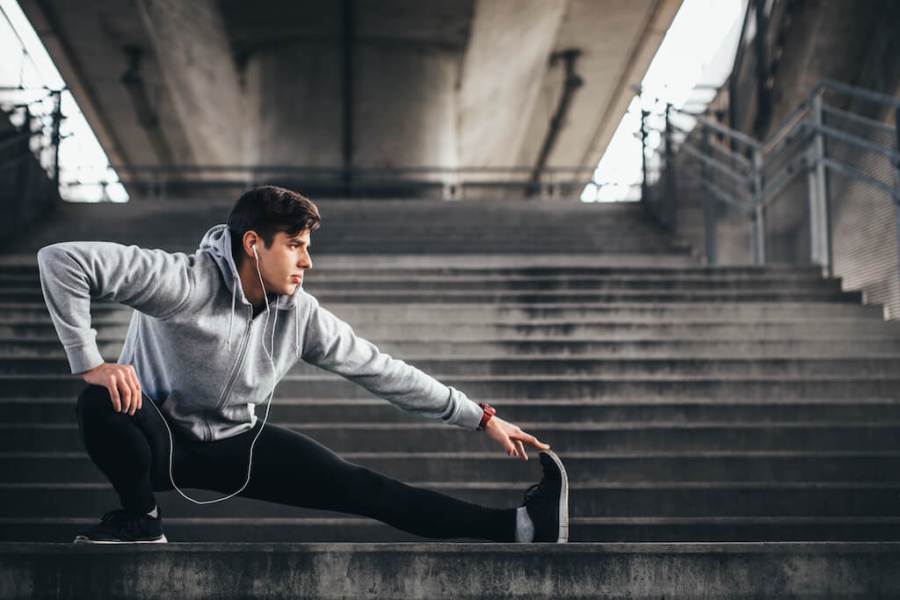 Athletic man stretching after a run on a set of outdoor steps