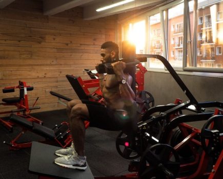 Man exercising in a gym on a hack squat machine