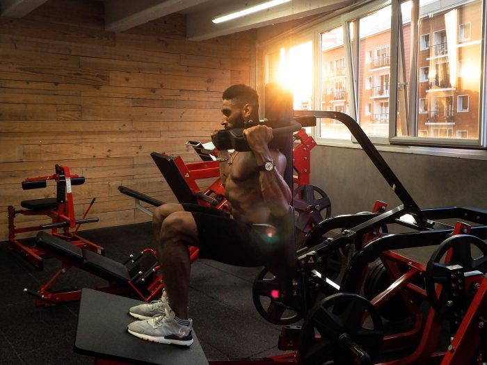 Man exercising in a gym on a hack squat machine