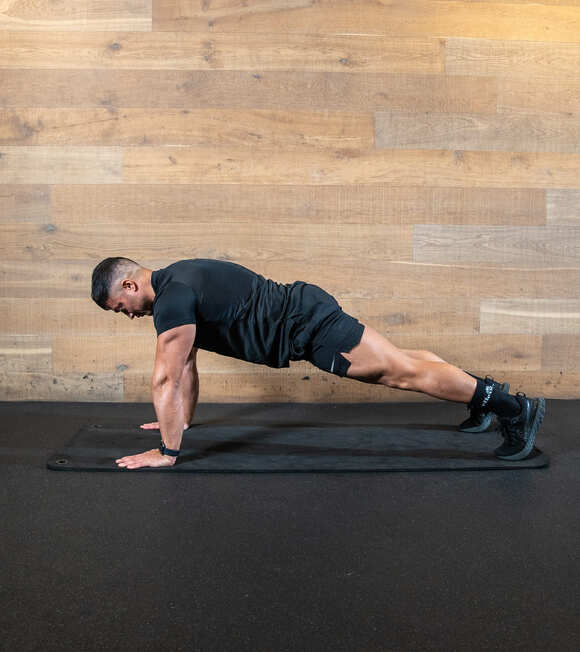Part of the best full-body dumbbell workout: man in high plank - opening position for world's greatest stretch