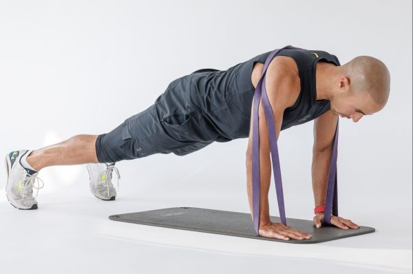 Man performing banded press-up in resistance band full-body workout