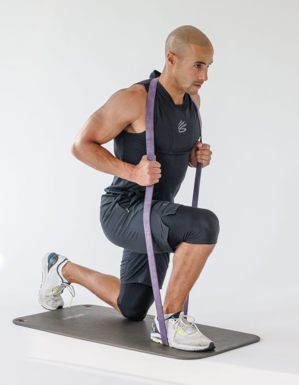Man performing a banded reverse lunge in resistance band full-body workout