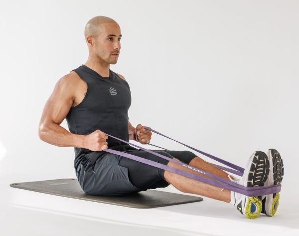 Man performing a banded seated back row in resistance band full-body workout