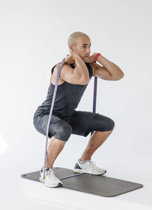 Man performing banded front squat in resistance band full-body workout