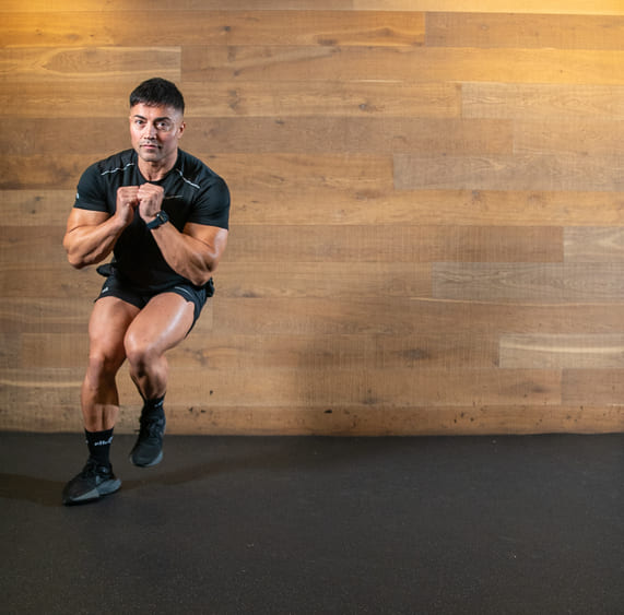 Part of the best full-body dumbbell workout: man demonstrates lateral bounds; he jumps from side to side