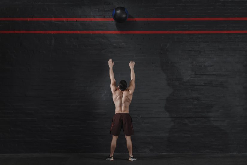 Man throwing ball up to lines high on a wall