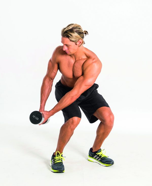 Man exercising, performing a dumbbell wood chop in dumbbell abs workout