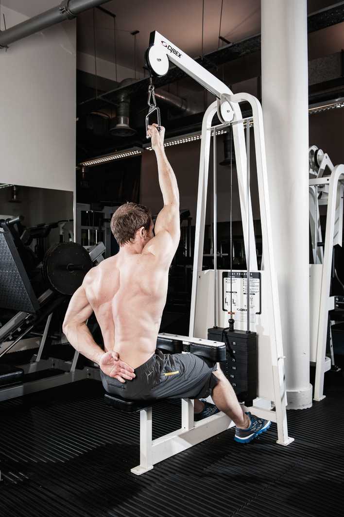 man demonstrates how to do single arm lat pull down