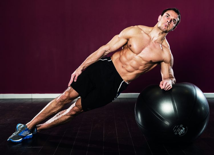 Man performing gym ball side plank