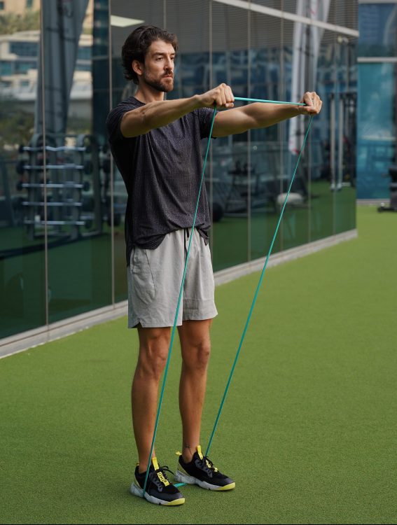 Man performing end of band front raise - resistance band upper body workout