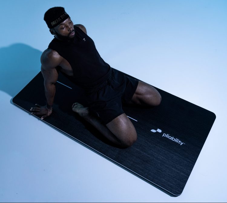 Althete performing a saddle pose on a yoga mat, post-workout mobility routine