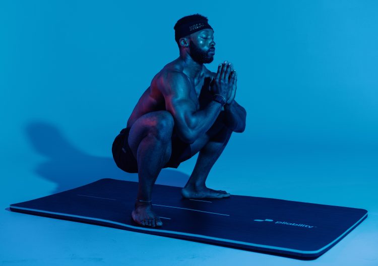 Athlete performing a sumo squat on a yoga mat