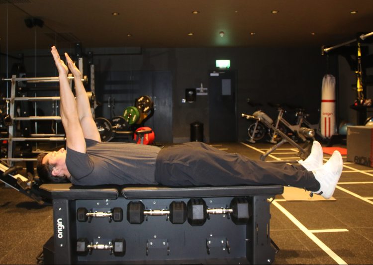 Man performing the start of a V-sit exercise 