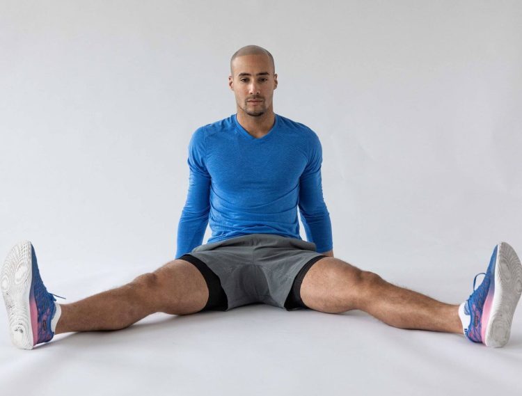 Man performing a wide-angle seated forward stretch - best hip stretches