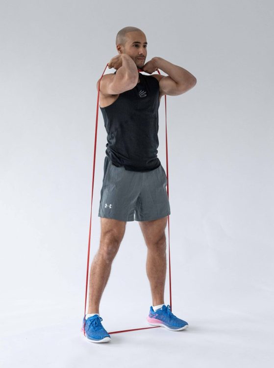 Man performing a banded squat - resistance band leg exercises