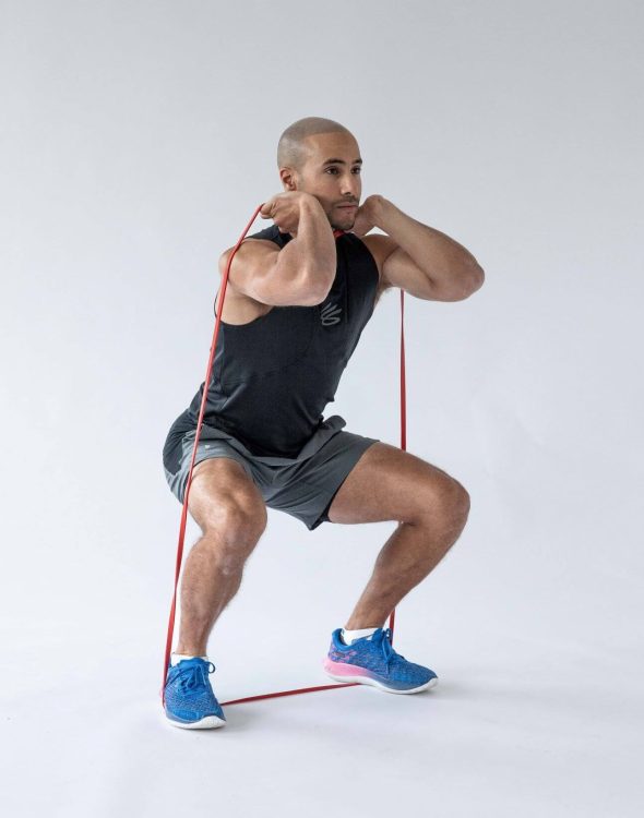Man performing end of a banded squat 
