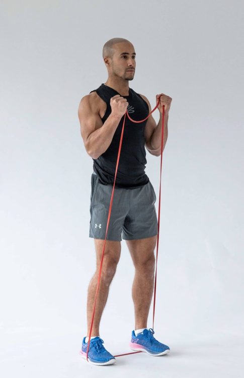 Man performing end of a banded biceps curl - resistance band arm exercises