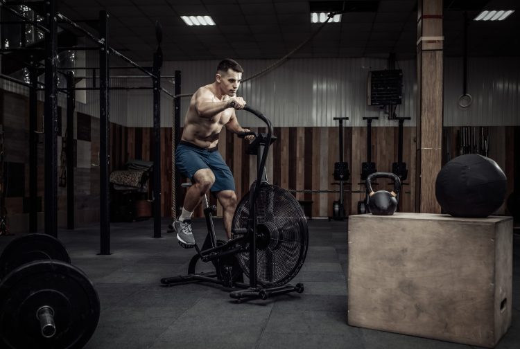 A man in a gym exercising on an air bike