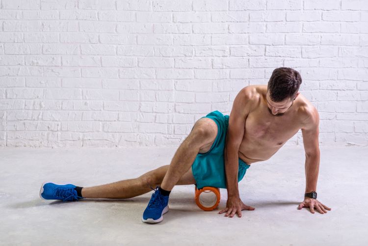 Man using a foam roller on his hips
